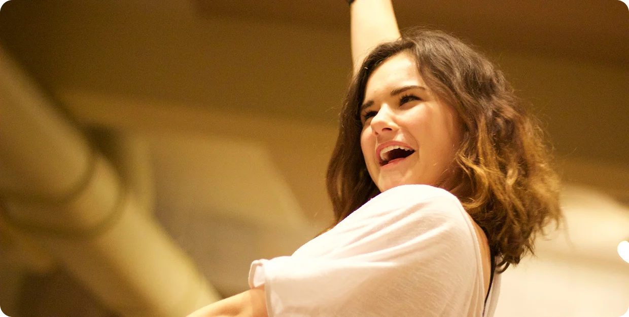 Person raising an arm in a joyful, expressive gesture, reflecting vitality and sensory awareness.