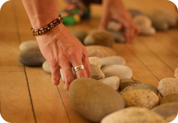 Hands gently arranging smooth stones as a symbol of mindfulness and sensory awareness